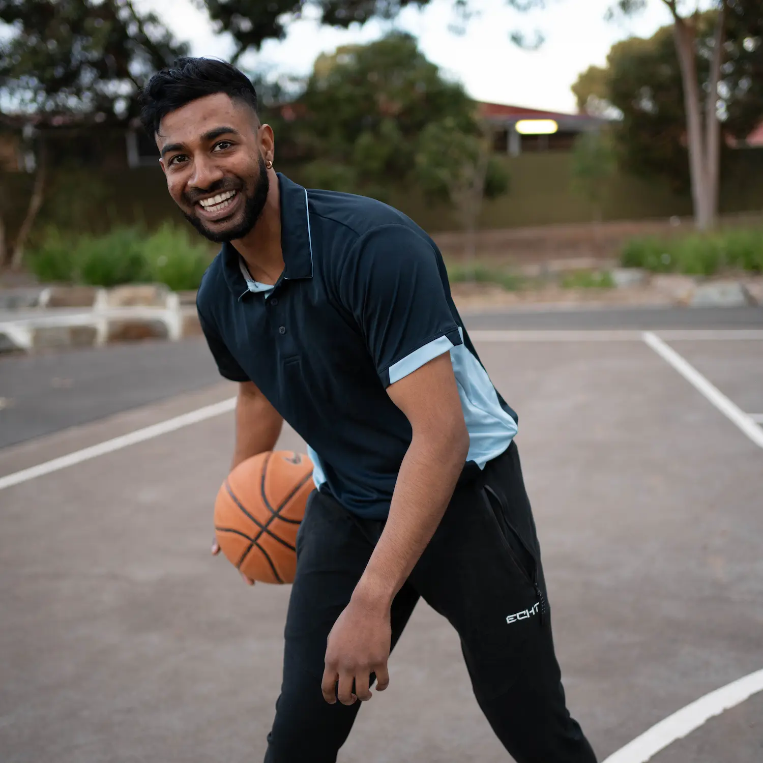 Kas bouncing a basketball on a court outside